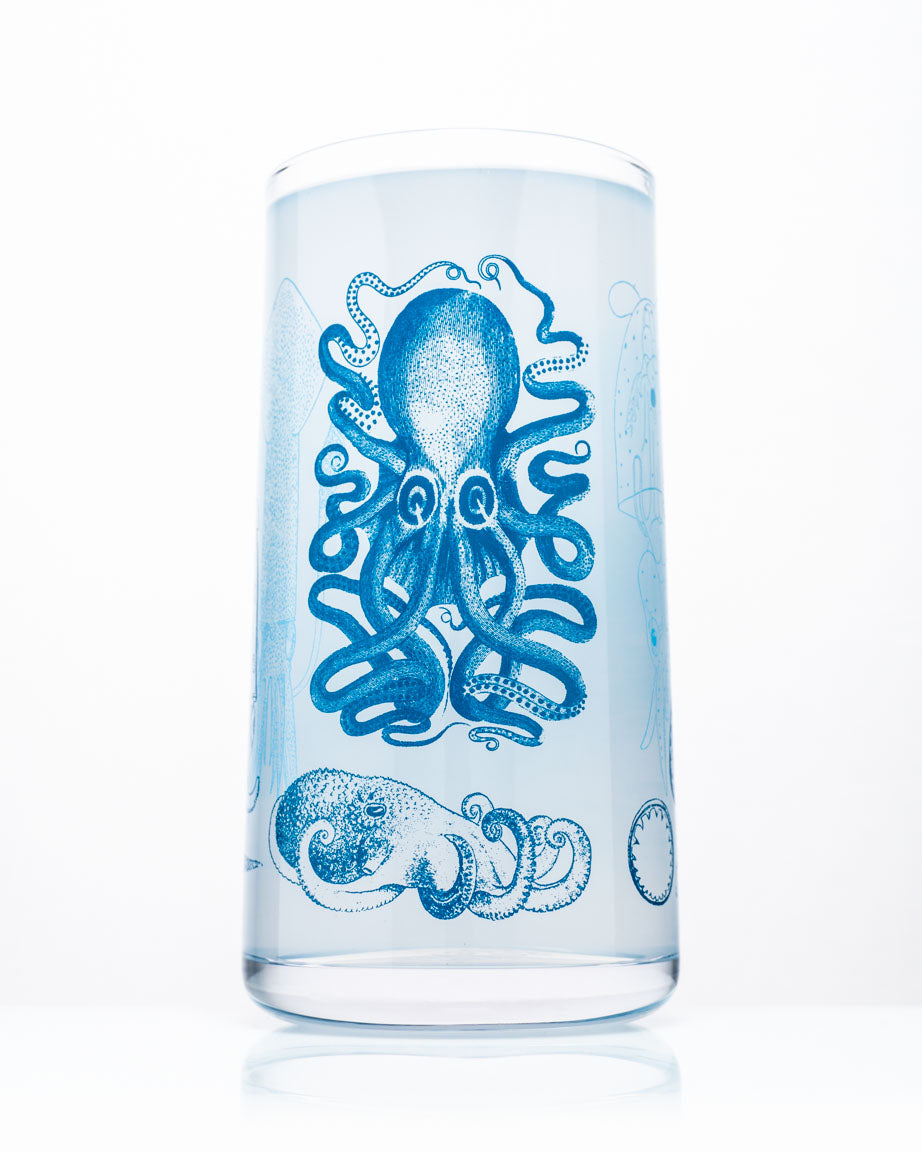 A Monsters of the Deep: Cephalopods Drinking Glass by Cognitive Surplus on a white surface.
