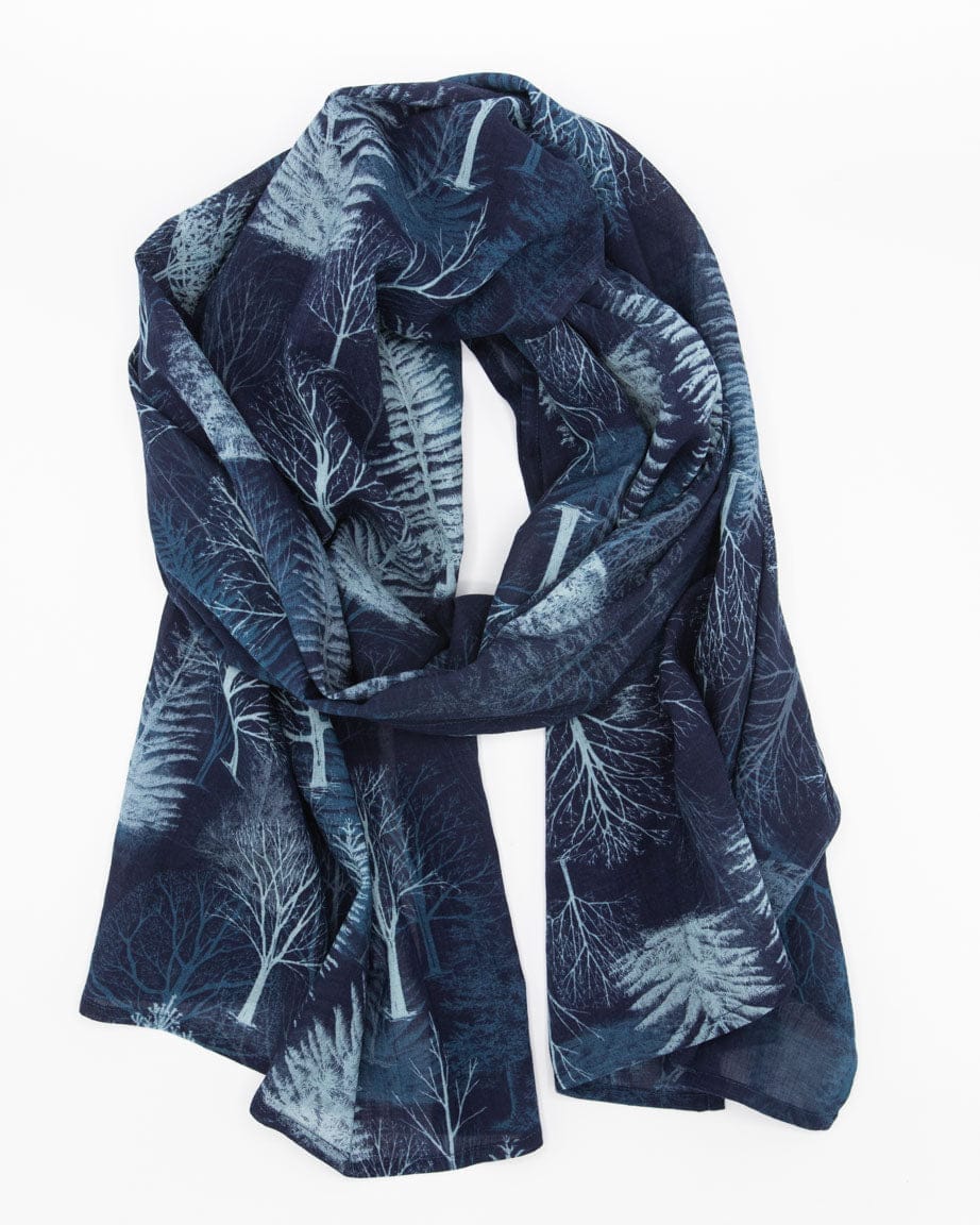 A blue scarf with a white winter tree pattern draped in a loop.