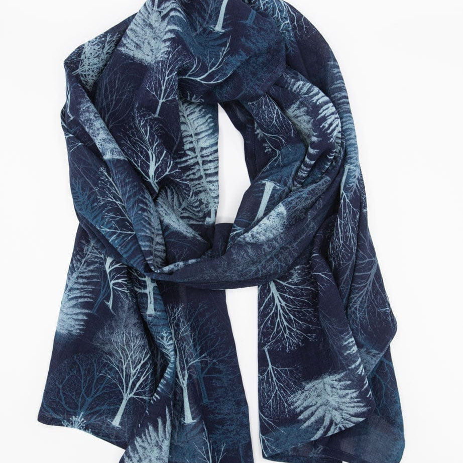 A blue scarf with a white winter tree pattern draped in a loop.