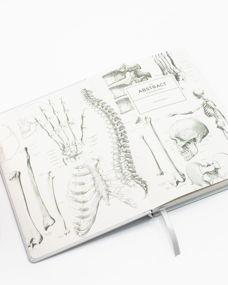 A Cognitive Surplus Skeleton A5 Hardcover Notebook - Dotted Lines with a drawing of a skeleton on it.