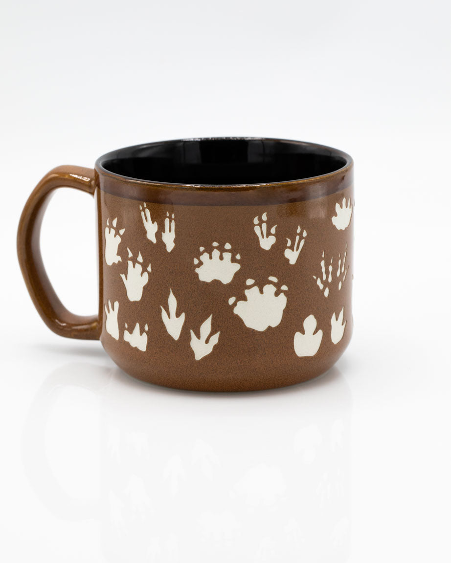 A Dinosaur Footprints Hand Carved 15 oz Ceramic Mug with footprints on it by Cognitive Surplus.