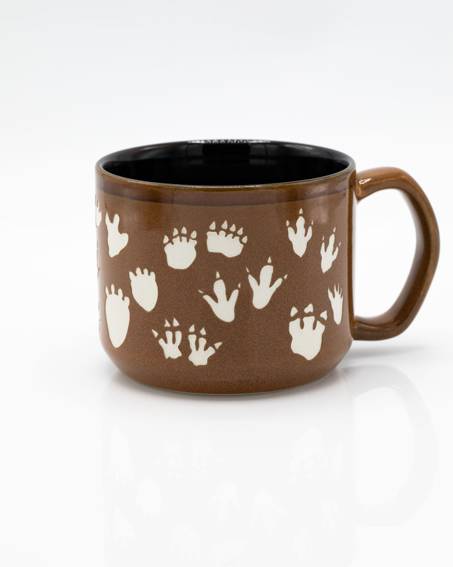 A Dinosaur Footprints Hand Carved 15 oz Ceramic Mug with footprints on it by Cognitive Surplus.
