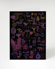 A black and purple Neon Mushrooms Greeting Card with a variety of mushrooms on it, by Cognitive Surplus.