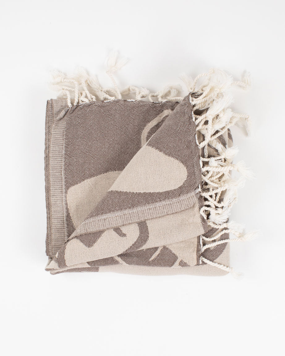 A brown and white Edible & Poisonous Mushrooms Turkish Towel with tassels on it. (Brand: Cognitive Surplus)