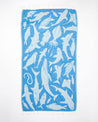 A blue Ocean Explorer Turkish Towel with sharks on it by Cognitive Surplus.