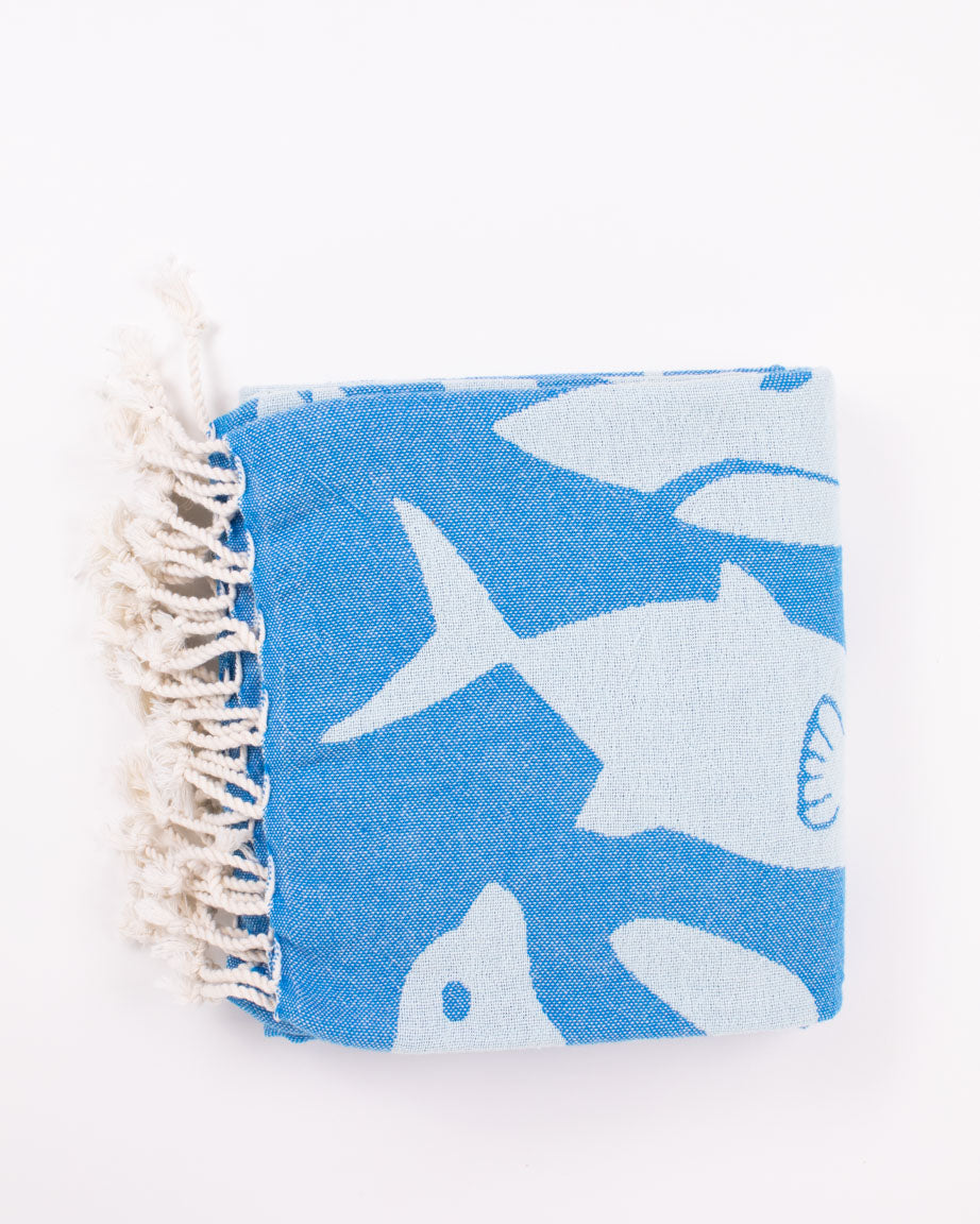 A blue and white Ocean Explorer Turkish Towel with fish on it from Cognitive Surplus.