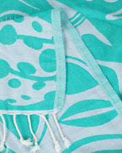 A teal and white Go With the Flow: Plankton Turkish Towel with tassels on it by Cognitive Surplus.