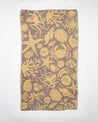A yellow and brown Tide Pool Turkish Towel with an octopus on it.