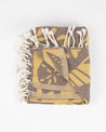 A Tide Pool Turkish Towel by Cognitive Surplus, yellow and black with tassels.