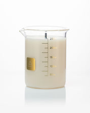 A Cognitive Surplus beaker filled with The Beaker Candle on a white background.