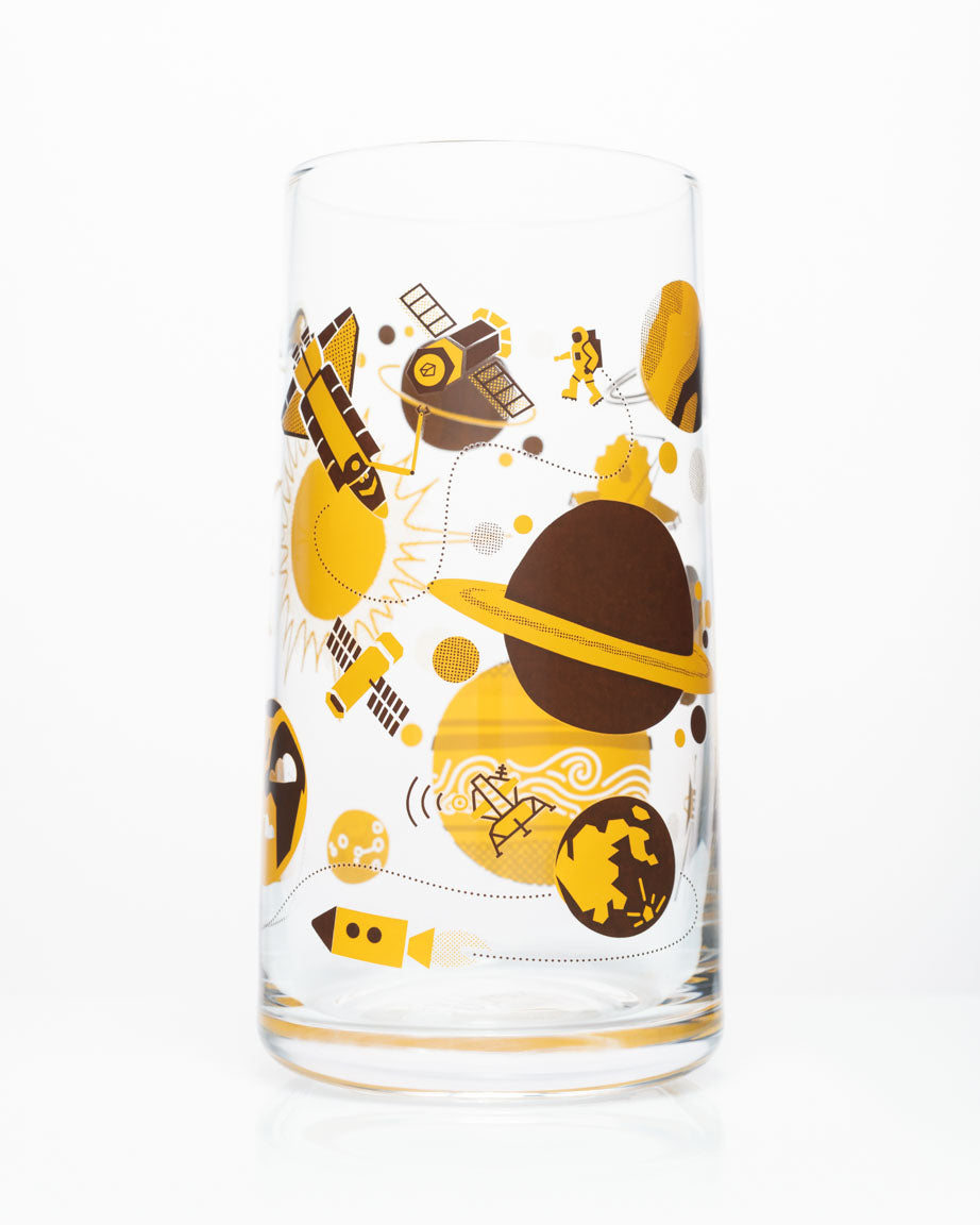 A Retro Space Drinking Glass with a Cognitive Surplus space themed design on it.