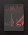 A Into the Earth: Caves Dark Matter Notebook by Cognitive Surplus with an image of a cave and a red light.