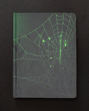 An image of the Spiders & Webs Dark Matter Notebook by Cognitive Surplus on a black background.