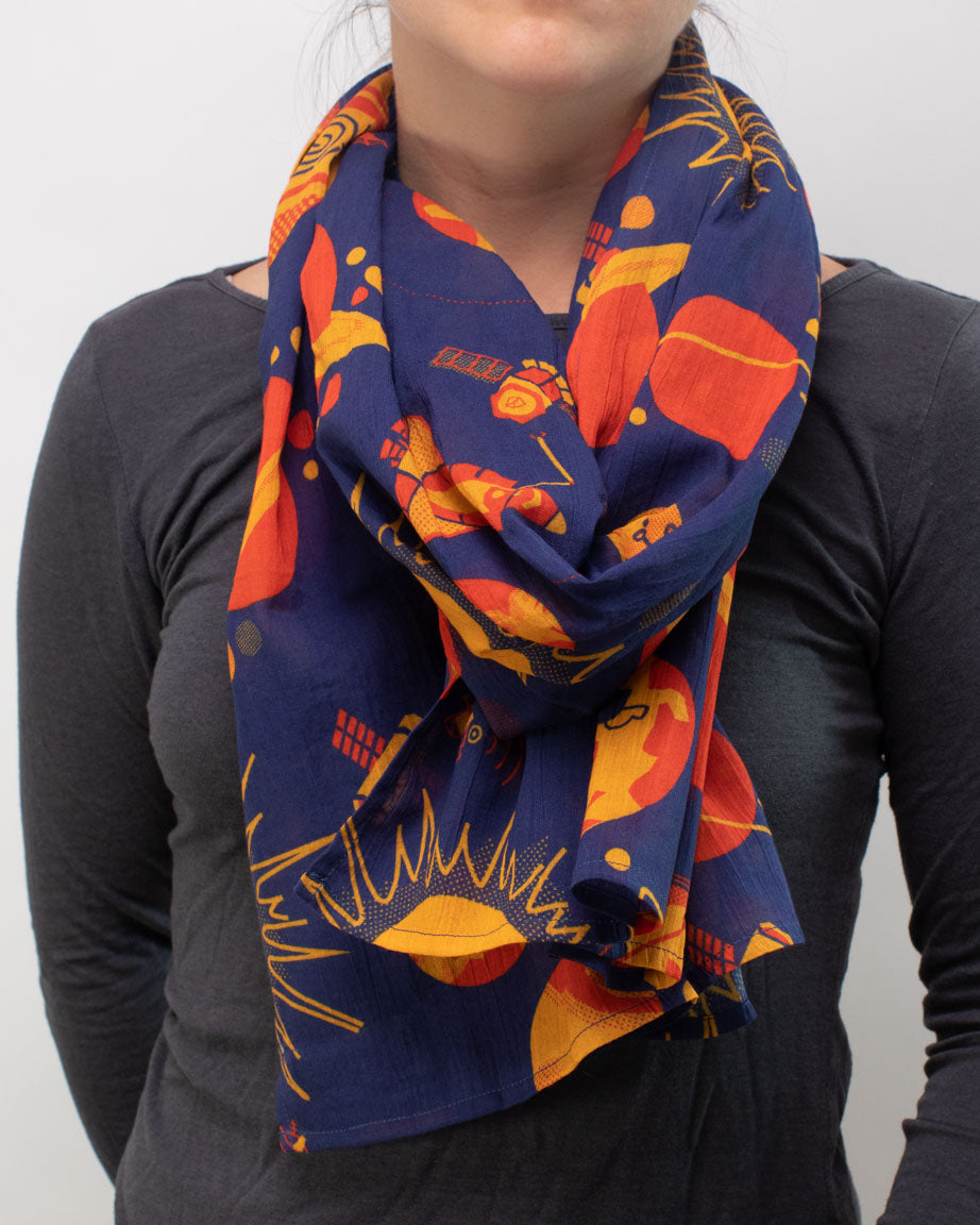 A woman wearing a Retro Astronomy Scarf from Cognitive Surplus with orange and yellow leaves.