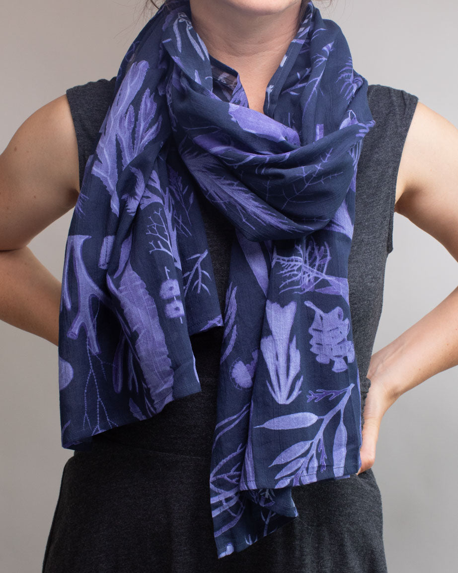A woman wearing a Cognitive Surplus Seaweed Scarf in blue and purple.