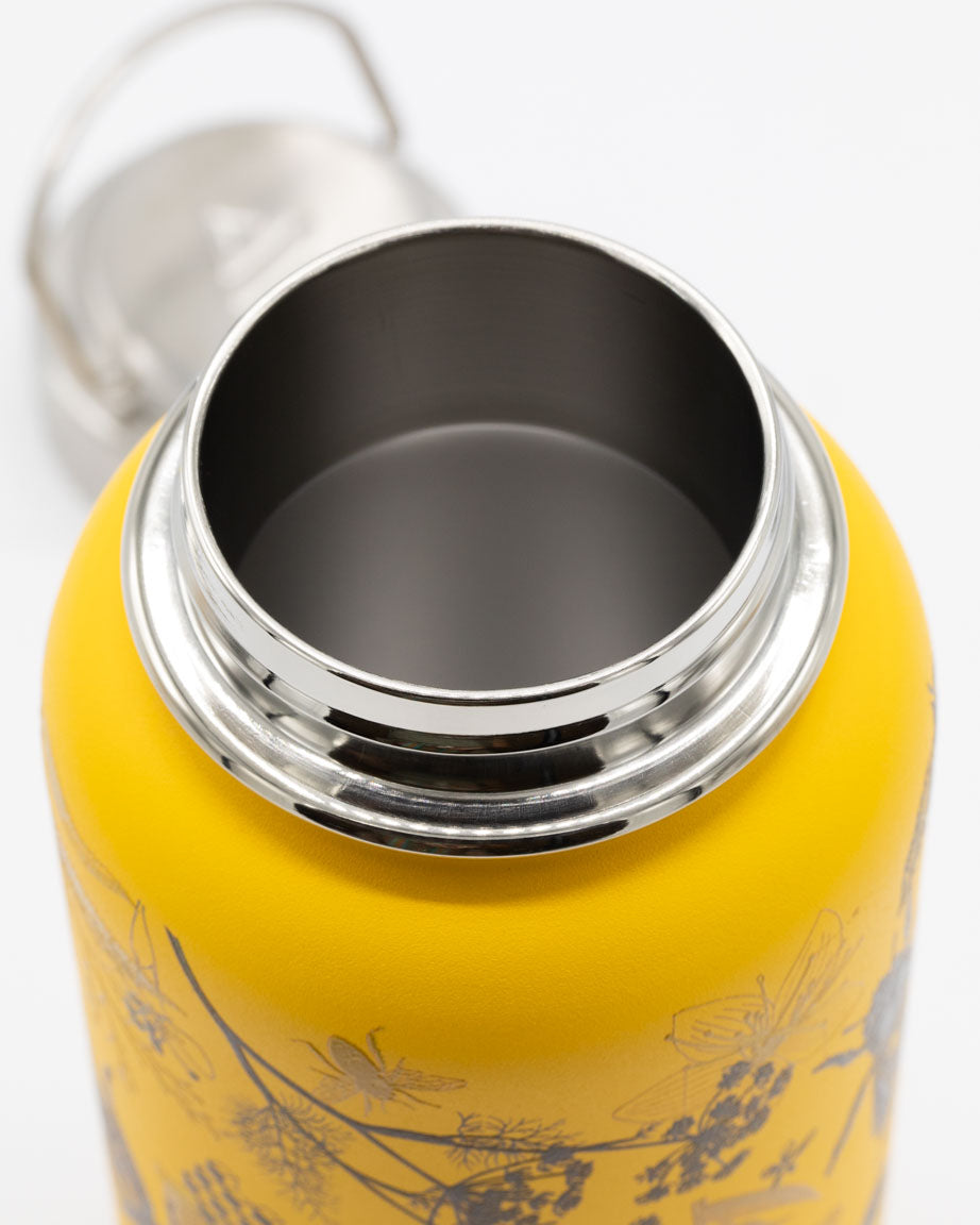 A Honey Bee 32 oz Steel Bottle with a silver lid on a white surface.