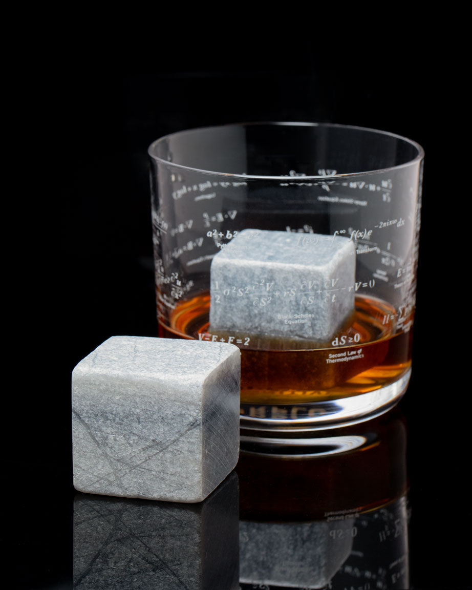 Mega Rocks Soapstone Whiskey Stones with a glass of whiskey. (Brand: Cognitive Surplus)