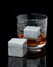 Mega Rocks Soapstone Whiskey Stones with a glass of whiskey. (Brand: Cognitive Surplus)