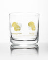 A Hominid Skulls Whiskey Glass with a yellow and white design on it by Cognitive Surplus.