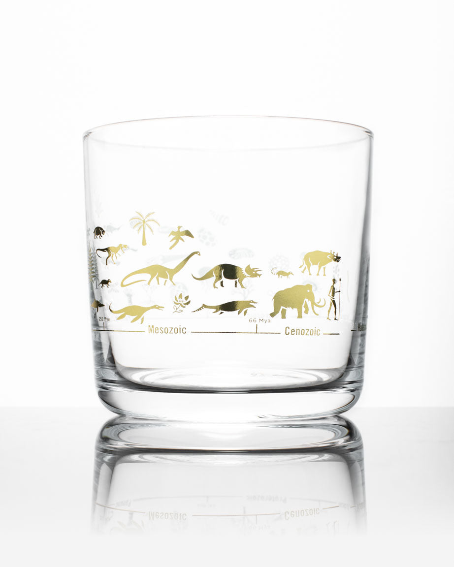 A Cognitive Surplus Geologic Time Scale Whiskey Glass with a design of dinosaurs on it.