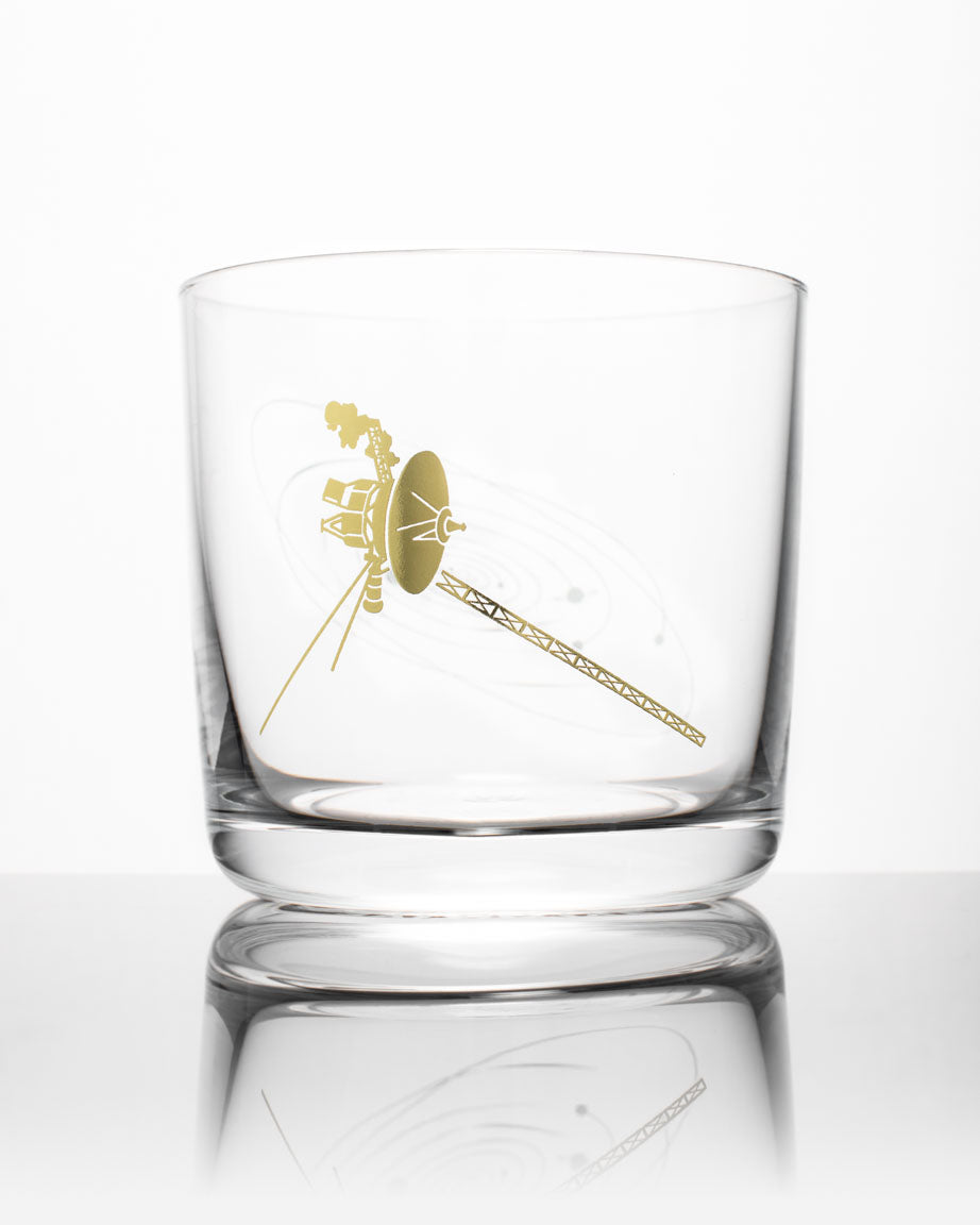 A Voyage to the Unknown Whiskey Glass with a gold design on it by Cognitive Surplus.