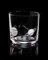 A Solar System Whiskey Glass by Cognitive Surplus with planets on it is on a black surface.