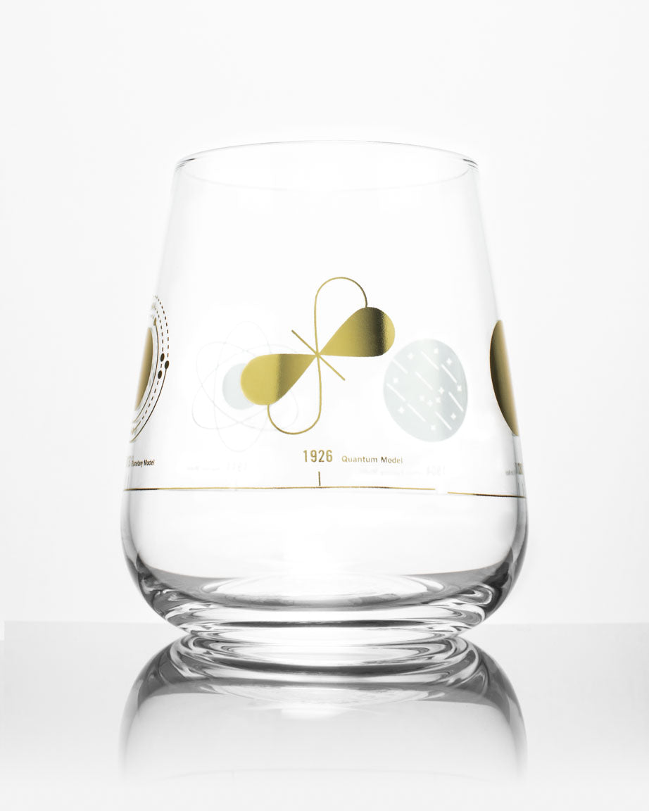 An Atomic Models Wine Glass with a gold design on it from Cognitive Surplus.