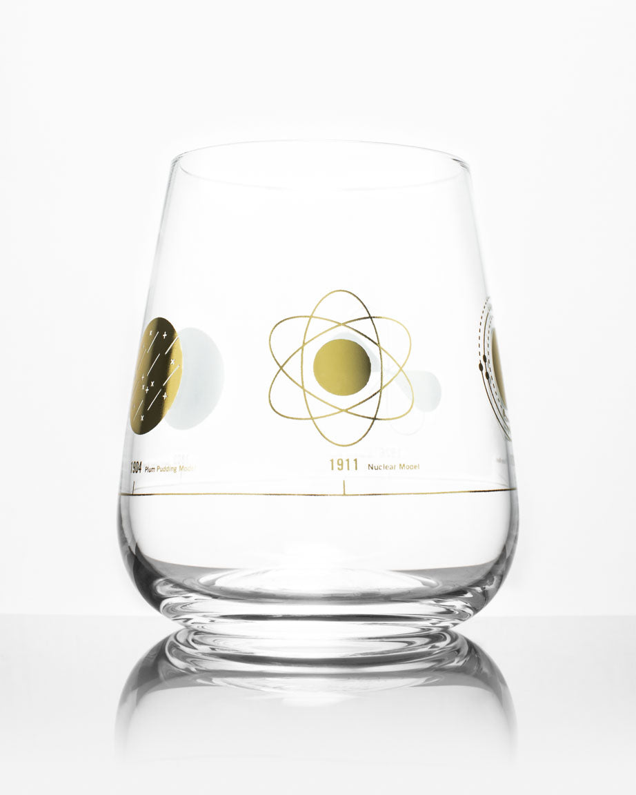 An Atomic Models Wine Glass with a gold and silver design on it, by Cognitive Surplus.