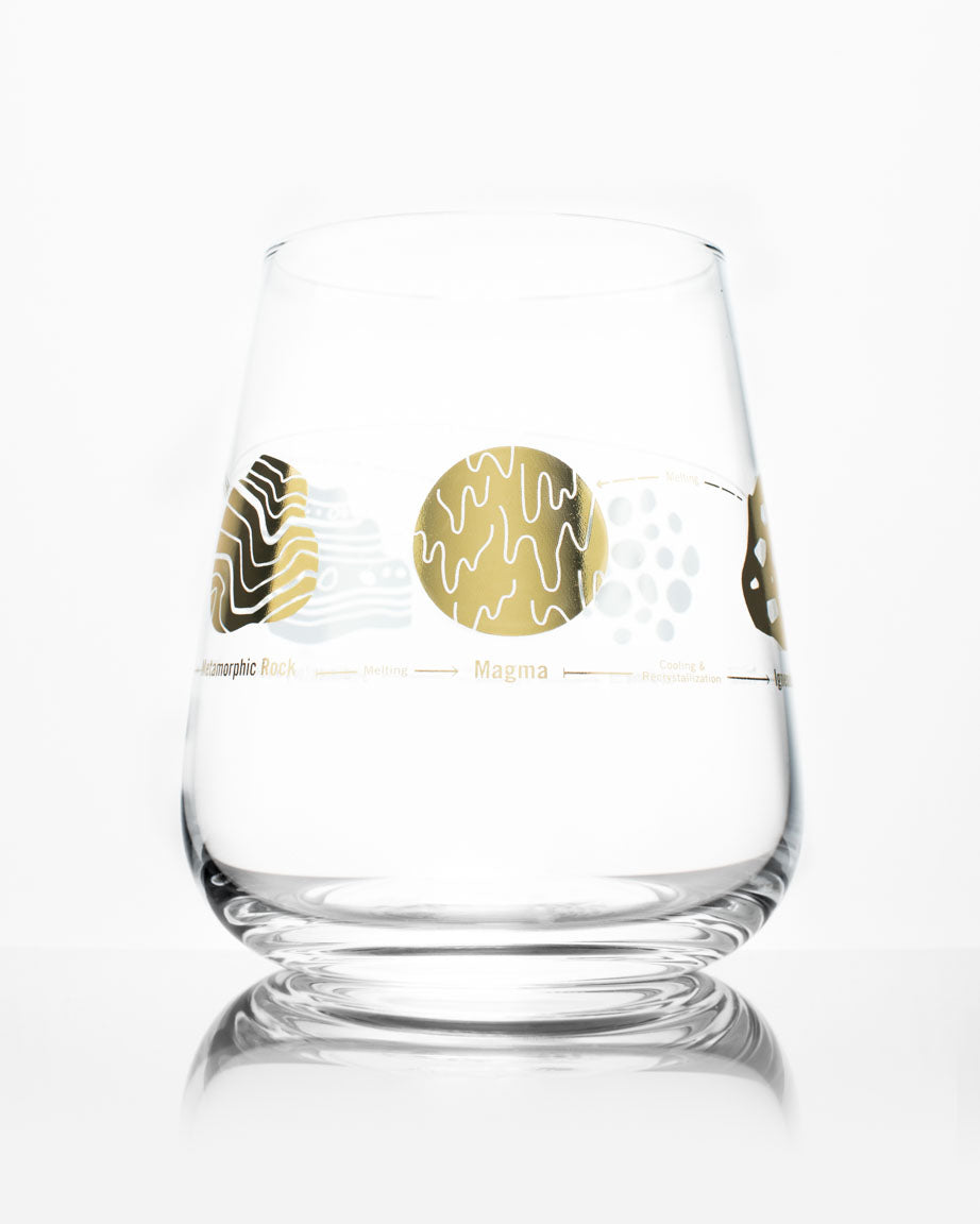 A Rock Cycle Wine Glass with a gold design on it by Cognitive Surplus.
