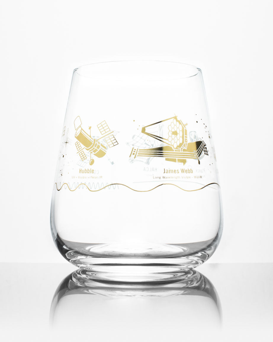 A Space Telescopes Wine Glass with a gold design on it by Cognitive Surplus.