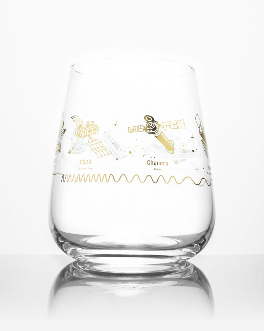A Space Telescopes Wine Glass with a gold and silver design on it by Cognitive Surplus.