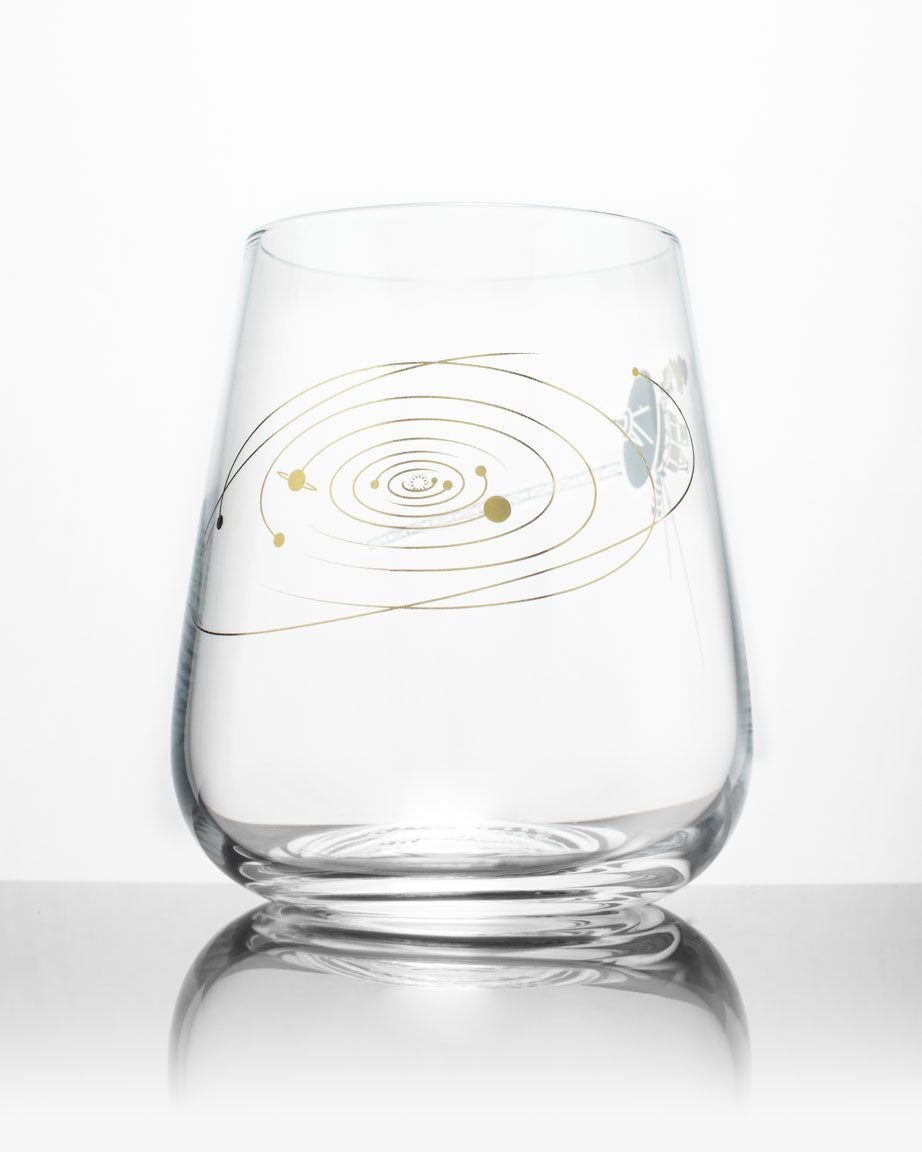 A SECONDS: Voyage to the Unknown Wine Glass by Cognitive Surplus with a design of a solar system on it.