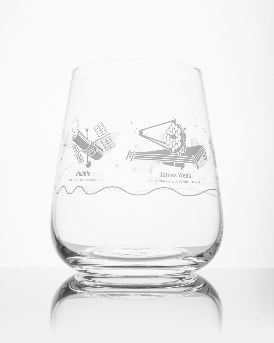 A SECONDS: Space Telescopes Wine Glass by Cognitive Surplus with a drawing of a spacecraft on it.